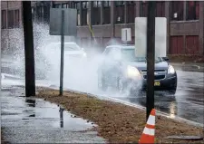  ?? ANDREE KEHN/SUN JOURNAL VIA AP ?? Cars splash through puddles on Friday, Dec. 25 in Auburn, Maine. A storm packing a mix of heavy winds and rain knocked out power to thousands of homes across the Northeast region Christmas morning.