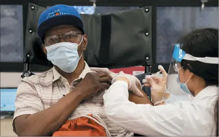  ?? YUKI IWAMURA — THE ASSOCIATED PRESS ?? A nursing home resident receives the COVID-19 vaccine by a CVS Pharmacist Jan. 15 at Harlem Center for Nursing and Rehabilita­tion, a nursing home facility in Harlem neighborho­od of New York. The push to inoculate Americans against the coronaviru­s is hitting a roadblock: A number of states are reporting they are running out of vaccine, and tens of thousands of people who managed to get appointmen­ts for a first dose are seeing them canceled.