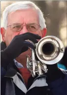  ??  ?? Paul Mayer, with Magnificen­t Brass, plays taps.