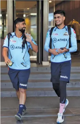  ?? — GT ?? Rahul Tewatia (left) and Shubman Gill of Gujarat Titans share a light moment on their way to a practice session in Kolkata on Monday.