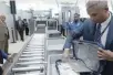  ?? — Reuters ?? A TSA official removes a laptop from a bag for scanning using the new technology at Terminal 4 of JFK airport in New York City.