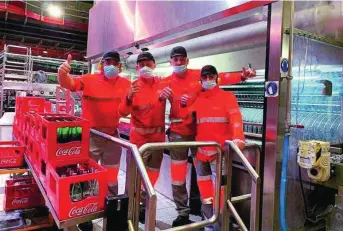  ??  ?? Empleados de Coca-Cola celebran el galardón en la planta de Sevilla