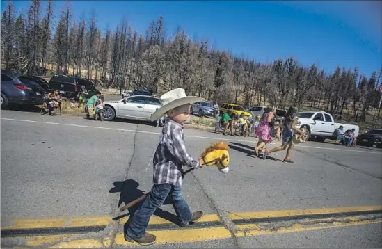  ?? Francine Orr Los Angeles Times ?? TRENTON SAVALA, 4, marches with his hobby horse in Greenville’s Gold Diggers Day parade. A year ago, the Dixie fire tore through the tiny Plumas County town.