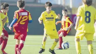  ??  ?? Un jugador de l’aleví F del Villarreal tracta d’avançar amb la pilota controlada. (( =
