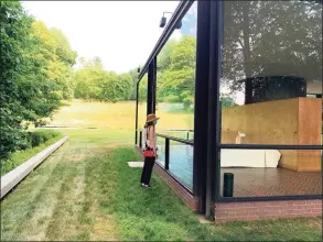  ?? Christa Carr / Contribute­d photo ?? Noelle Newelle peers into the Glass House in New Canaan, which will be opening to the public for the first time since 2019.