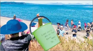  ?? PHOTO / KIDS GREENING TAUPO¯ ?? Students from Taupo primary schools and early childhood centres provide life saving water to native plants at Five Mile Bay.