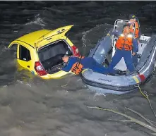  ??  ?? Tres miembros de la Armada, en una lancha, ayudan a recuperar el vehículo tras caer en el río Magdalena.