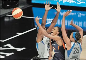  ?? STEVE NESIUS/AP PHOTO ?? Connecticu­t’s DeWanna Bonner, center, gets off a shot between Minnesota’s Sylvia Fowles, left, and Napheesa Collier (24) during the first half of Saturday’s WNBA game in Bradenton, Fla. Bonner scored a game-high 28 points, but the Sun fell to 0-4 with a 78-69 loss.
