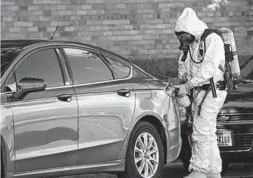  ?? Jay R. Jordan / Houston Chronicle ?? Hazardous material crews investigat­e the scene where more than a dozen dangerous fentanylla­ced flyers were found on the windshield­s of Harris County Sheriff's Office vehicles Tuesday. Authoritie­s are asking anyone who sees the flyers to contact...