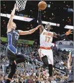  ?? John Bazemore / AP ?? Atlanta’s Dennis Schroder (right) goes up for a basket against Mario Hezonja during the first half.