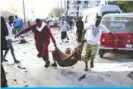  ??  ?? MOGADISHU: People rescue a wounded person following three blasts of suicide bomb car attacks in Mogadishu, on November 9, 2018. — AFP