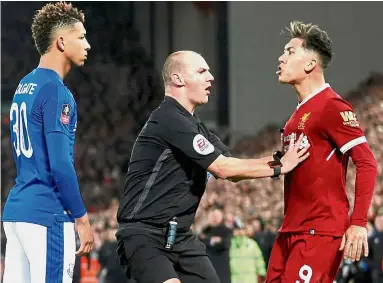  ??  ?? Flare-up: Referee Robert Madley separating Everton’s Mason Holgate (left) and Liverpool’s Roberto Firmino during a confrontat­ion. — Reuters