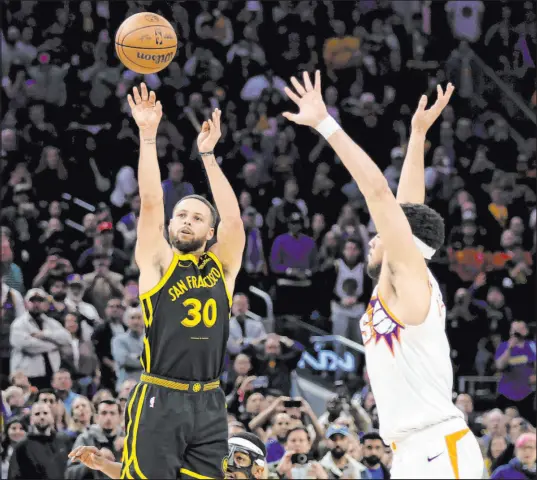  ?? Jed Jacobsohn
The Associated Press ?? Warriors guard Stephen Curry uncorks a 33-foot shot against Suns guard Devin Booker for the winning 3-pointer in the final second of Golden State’s 113-112 victory Saturday night at Chase Center. Curry had 30 points, nine rebounds and six assists.