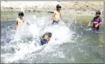  ??  ?? Children play in a water stream in the Iraqi city of Najaf on July 31. The stream that had been dried out for months was filled with water on Tuesday when the authoritie­s dug up wells in order to manage a droughtcri­sis. (AFP)