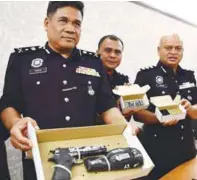  ??  ?? Yahya (left) and officers showing the seized pistol and bullets.