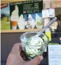  ?? XAVERIA RAHMANI UTAMI/JAWA POS ?? OISHII: Soft cream berbahan susu sapi segar dengan topping green tea ini banyak dijual di area tempat wisata Air Terjun Shiraito.