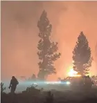  ??  ?? A wildfire burns Saturday night in southern Oregon.