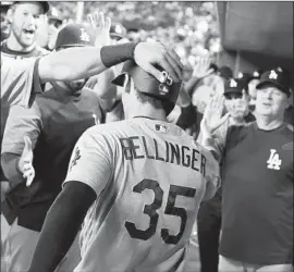  ??  ?? CODY BELLINGER IS greeted in the dugout after his home run in the second inning, his 24th homer of the season, gave the Dodgers a 1-0 lead.