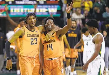  ?? RON JENKINS GETTY IMAGES ?? Oklahoma State’s Tyreek Smith (23) and Bryce Williams celebrate after defeating top-ranked Baylor.