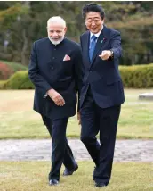  ?? — AP ?? Prime Minister Narendra Modi and Japan’s Prime Minister Shinzo Abe walk together at a hotel garden in Yamanakako village, Yamanashi prefecture, on Sunday.