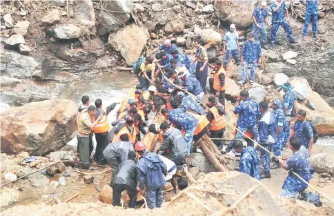  ??  ?? Indian Army personnel and Kerala state police work to build a temporary bridge over a rocky river following heavy flooding in Nelliyampa­thy in Palakkad district, in the Indian state of Kerala. — AFP photo