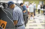  ?? RICARDO B. BRAZZIELL / AMERICANST­ATESMAN ?? People vote March 1 at the Travis County tax office. The new system will let voters see paper copies of their selections.