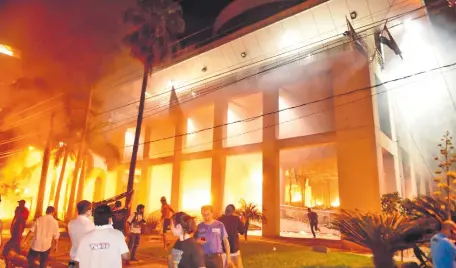  ?? ?? Manifestan­tes contra la enmienda queman parcialmen­te la sede del Senado, luego de que la Policía haya abandonado el sitio.