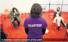  ??  ?? A volunteer assists members of the public