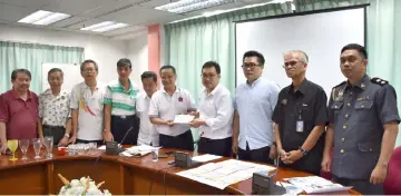  ??  ?? Tong (fifth right) hands over a letter to Chong pertaining to the problems faced by coffee shop operators in Sibu, while (from sixth right) Wong, Tan, Md Nawawi, Roslee and others look on.