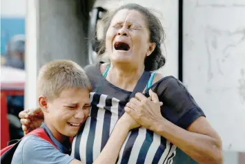  ??  ?? Relatives of inmates held at the General Command of the Carabobo Police react as they wait outside the prison, where a fire occurred in the cells area, in Valencia, Venezuela. — Reuters
