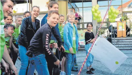  ?? FOTO: AXEL PRIES ?? Kommt eine Aufgabe geflogen: Unter dem Gejohle der Laupheimer Gruppe rutscht das Kuvert vom ersten Stock des Rathauses am Seil herunter.