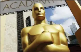  ?? Photos and text from wire services PHOTO BY MATT SAYLES — INVISION — AP, FILE ?? In this file photo, an Oscar statue appears outside the Dolby Theatre for the 87th Academy Awards in Los Angeles.