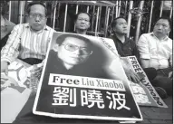  ?? Vincent Yu/AP ?? Critical: Protesters display portrait of jailed Chinese Nobel Peace laureate Liu Xiaobo during a demonstrat­ion outside the Chinese liaison office in Hong Kong, on Monday. The hospital treating imprisoned Chinese Nobel Peace Prize laureate Liu Xiaobo...