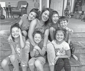  ?? ALYSSA SPERAZZA/ HOWARD CENTER FOR INVESTIGAT­IVE JOURNALISM ?? Ashley Fitzgibbon and her children sit outside their Oklahoma City rental home. Fitzgibbon lost her income when the state shut down. From left the Fitzgibbon family members are Adaley Joy, 9; Jayden Grace, 12; Rorke, 5; Ashley, 35; Judah, 10; M’kenna Lou Ann, 6, and Griffin, 8.
