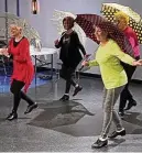  ?? ?? The Senior Sensations tap dance troupe includes (front row, crouching): Susie Todd, Sherry Wimmers and Sandy Christie. (Back row): Phyllis Treat, Judy Servaites, choreograp­her Jodi Quinn and Helen Terrell. Colorful umbrellas add a little flair to the Senior Sensations’ rehearsal for “Singin’ in the Rain.”