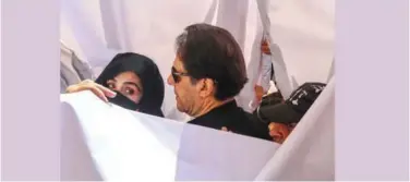  ?? Agence France-presse ?? ↑
Imran Khan (centre) and his wife Bushra Bibi (left) arrive to appear at the High Court in Lahore on Monday.