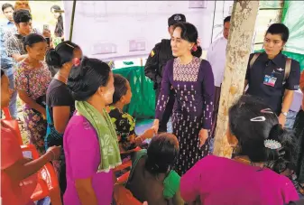  ?? AFP / Getty Images ?? Aung San Suu Kyi ( center) meets with residents in Rakhine State. An army campaign has forced most of the area’s Rohingya Muslim population to flee to neighborin­g Bangladesh.