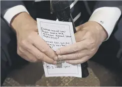  ??  ?? 0 Donald Trump holds notes during the ‘listening session’