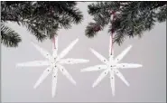  ?? WOMAN’S DAY VIA AP ?? This undated photo taken from video and provided by Woman’s Day shows shows star-shaped ornaments made from wooden clothespin­s. Crafting ornaments gives families an activity to do together and provides treasures for unpacking at future holiday...