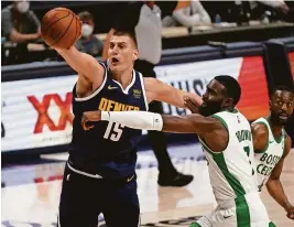  ?? RON CHENOY/USA TODAY SPORTS ?? Nuggets center Nikola Jokic (15) and Celtics guard Jaylen Brown (7) go after a loose ball on Sunday at Ball Arena in Denver.