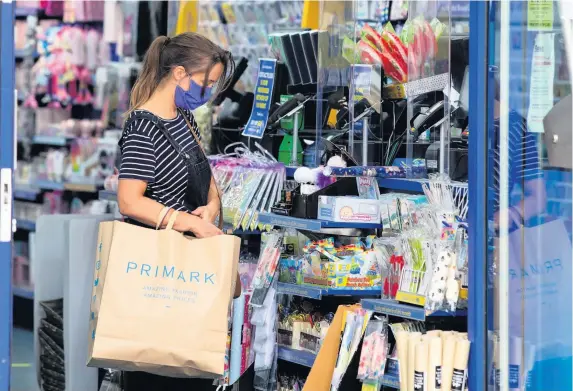  ?? SWNS ?? A Bristol shopper wearing a face mask – shop staff are now required to wear masks too