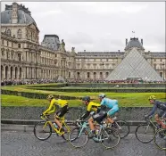  ?? THIBAULT CAMUS/AP PHOTO ?? The pack with Britain’s Chris Froome, wearing the overall leader’s yellow jersey, passes the Louvre museum during the final stage of the Tour de France on Sunday in Paris.