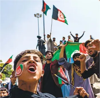  ?? MARCUS YAM LOS ANGELES TIMES ?? A group of Afghans tries to raise the national flag of the Islamic Republic of Afghanista­n, despite the presence of armed Taliban fighters around them, during a rally Thursday at Pashtunist­an Square in Kabul.