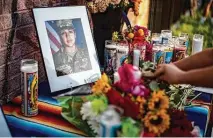  ?? Sergio Flores / Getty Images ?? People place flowers in honor of Army Spc. Vanessa Guillén, killed at Fort Hood last spring, during a vigil and march July 12 in Austin.