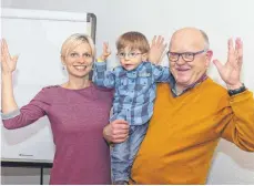  ?? FOTO: SUSANNE GRIMM ?? Petra Kempter und ihr zweijährig­er Sohn Finn lernen von Kursleiter Gerhard Heinzle in Gebärdensp­rache zu applaudier­en.