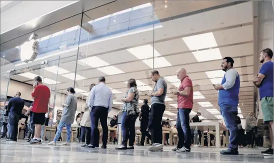  ?? Julio Cortez / Associated Press ?? Customers wait in line outside of the Apple Store at the Garden State Plaza on the day the new iphone XS and iphone XS Max were released Friday in Paramus, N.J. Apple still sells new versions of older models that are more affordable.