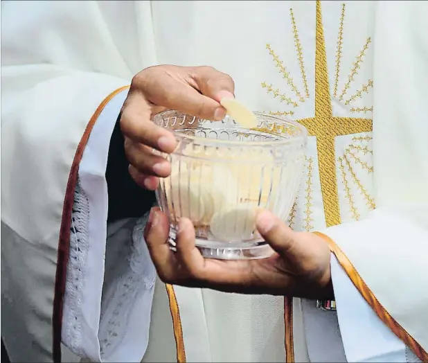  ??  ?? La normativa de la Iglesia católica acerca de la comunión indica que la forma sagrada que representa el cuerpo de Cristo debe ser con gluten