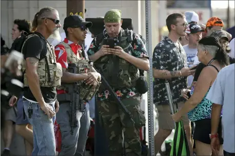  ?? CHARLIE RIEDEL — THE ASSOCIATED PRESS FILE ?? In this June 20, 2020file photo, gun-carrying men wearing Hawaiian print shirts associated with the boogaloo movement watch a demonstrat­ion near where President Trump had a campaign rally in Tulsa, Okla.