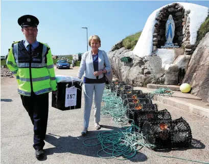  ??  ?? Garda Pat McIlroy and Gola Island presiding officer Nancy Sharkey depart the island with the ballot box as the Donegal island went to the polls a day ahead of the rest of the country in the referendum. Photo: Brian Lawless