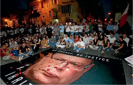  ?? PHOTO: REUTERS ?? Protesters throw tomatoes and coins on a banner calling on Malta’s police commission­er Lawrence Cutajar to resign, while blocking the road outside the Malta Police headquarte­rs during a protest over the assassinat­ion of investigat­ive journalist Daphne...